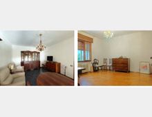 Interno di un’abitazione con due stanze: un soggiorno con divani, tavolo ovale, grande credenza in legno, TV su mobile e lampadario a chandelier. Seconda stanza con parquet, finestra con tapparella, termosifone, cassettiera e sedie lungo la parete, con piccolo lampadario al soffitto.